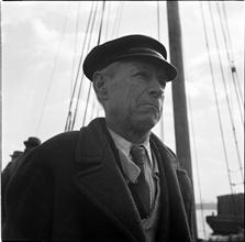 Waterfront. [Man with a mast in the background.]