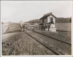 [Milk wagon crossing railroad tracks.]