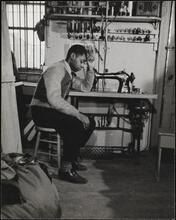 Black delivery boy "Freddie" in interior of tailor shop