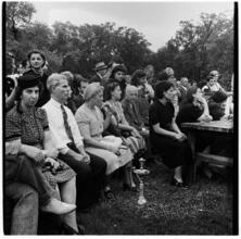 [Seated audience with a woman smoking a hookah.]
