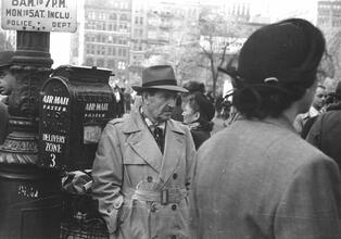 Untitled [Man in trench coat at crosswalk, near mailbox, Union Square]