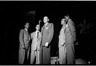 Vaughn Monroe [Monroe and a group of men singing on stage.]
