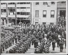 [Firemen saluting as a parade goes by.]