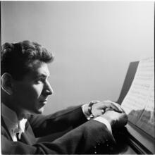 Leonard Bernstein [Leonard Bernstein at a piano looking at sheet music.]
