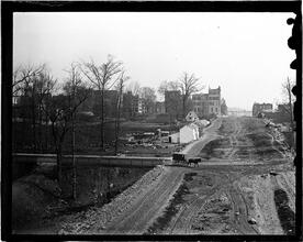 [Small farm dwellings next to a large road]