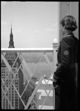 [Woman looking at 40 Wall Street from observation deck of 60 Wall Street.]