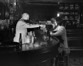 [Man and a woman at a bar.]