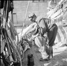 Waterfront. [Man working on deck.]