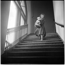 Columbia University [Student carrying a stack of books down stairs.]
