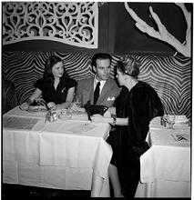 Champagne Cholly Book Party [A man and two women talking.]