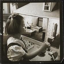 Orphanage [Girl playing with a dollhouse.]