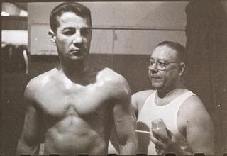 Rocky Graziano, He's a Good Boy Now [Man applying petroleum jelly to Rocky Graziano.]