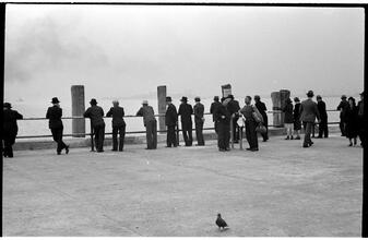[People waiting on the dock of the Hoboken Ferry Terminal.]