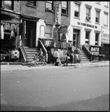 [Clothes for sale in front of 104-106 Rivington Street.]