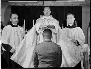 [Man kneeling before priest.]