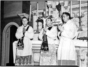 [Clergy at altar with a crucifix.]