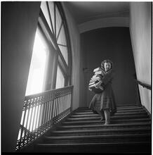 Columbia University [Woman with a large stack of books walking down a flight of stairs.]