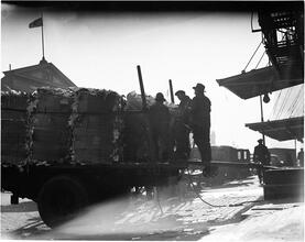Waterfront. [Cart loaded with bales of garbage.]